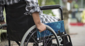 Pessoa com deficiência física, numa cadeira de rodas.